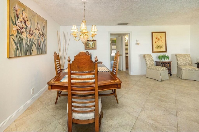 dining room with a textured ceiling and a notable chandelier