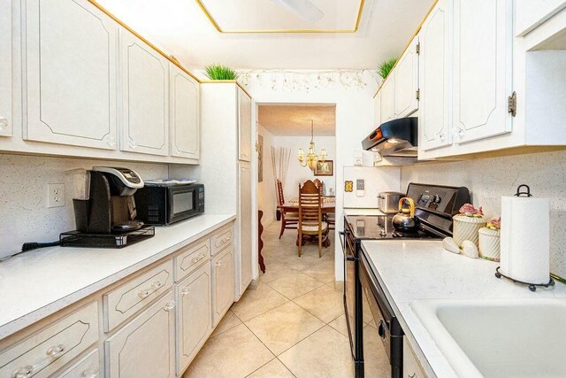 kitchen featuring light tile patterned floors, a notable chandelier, decorative light fixtures, white cabinets, and black appliances