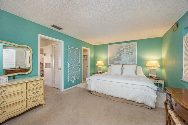 bedroom with light colored carpet and a textured ceiling