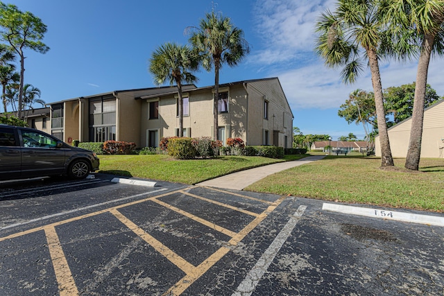 view of property with uncovered parking and a residential view