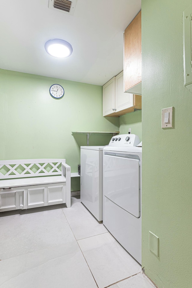 clothes washing area with cabinet space, visible vents, separate washer and dryer, and light tile patterned flooring