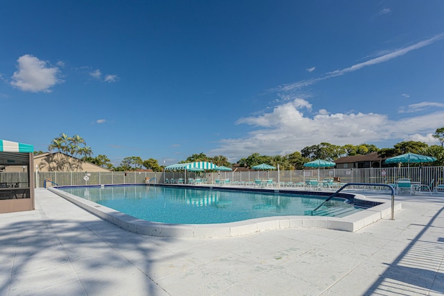 community pool with fence and a patio