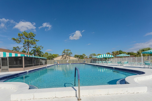 pool with a patio area and fence