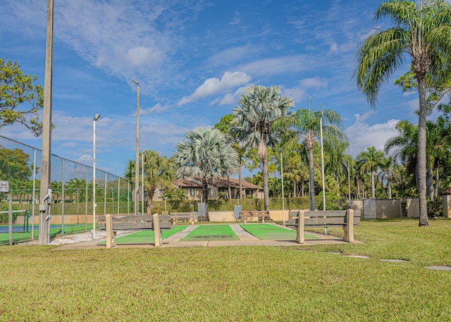 view of jungle gym featuring shuffleboard, a yard, and fence