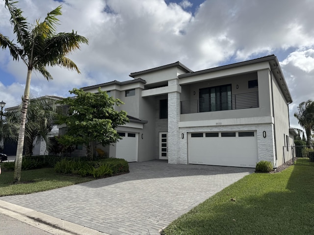 view of front of house with a balcony, a front lawn, and a garage