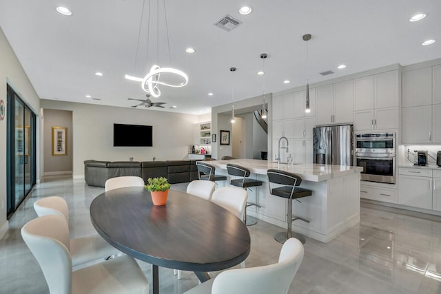 dining room featuring ceiling fan and sink