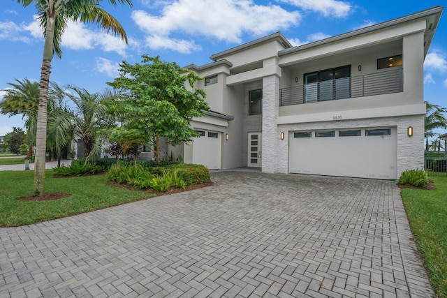 view of front facade with a front lawn, a garage, and a balcony