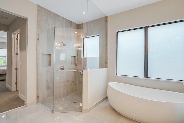 bathroom featuring tile patterned flooring and shower with separate bathtub