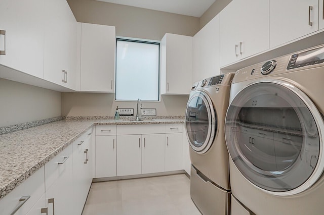 laundry area with washing machine and dryer, sink, and cabinets