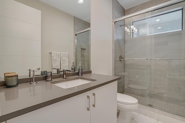 bathroom with a shower with door, toilet, and vanity