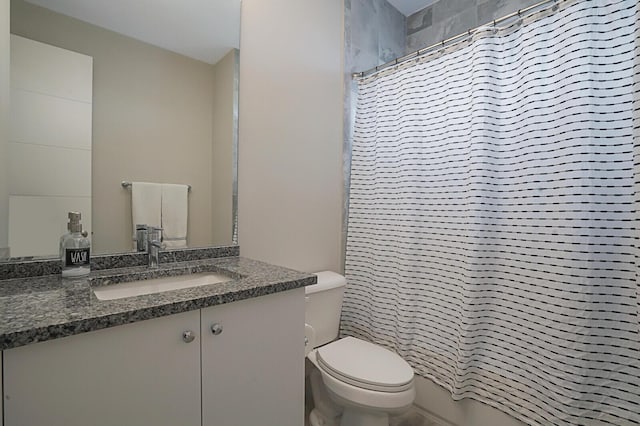 bathroom featuring toilet, vanity, and walk in shower