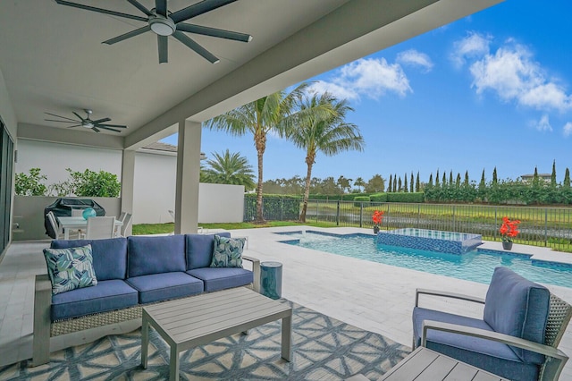 view of swimming pool with ceiling fan, an in ground hot tub, an outdoor living space, and a patio