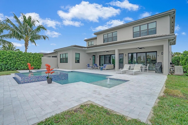 back of house featuring ceiling fan, a patio area, a swimming pool with hot tub, and an outdoor living space