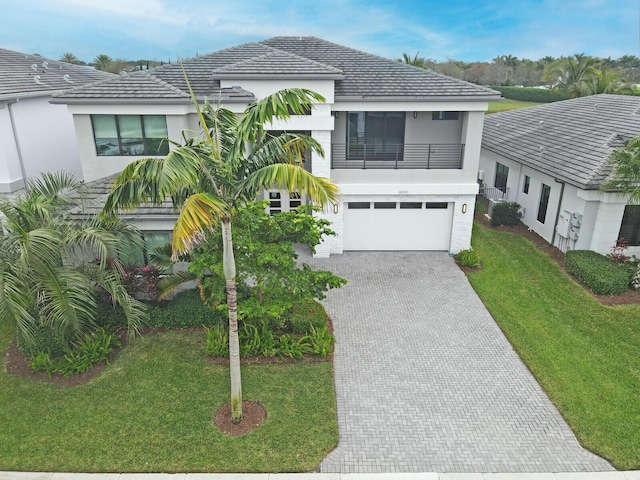 view of front of property with a front yard, a garage, and a balcony