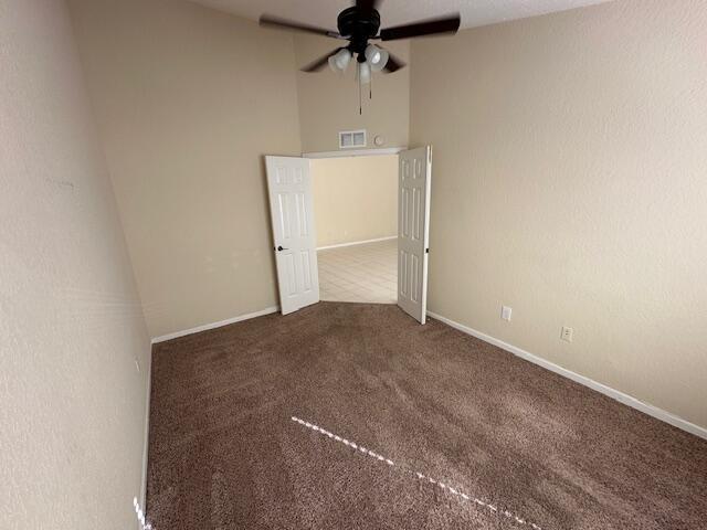 carpeted empty room featuring ceiling fan