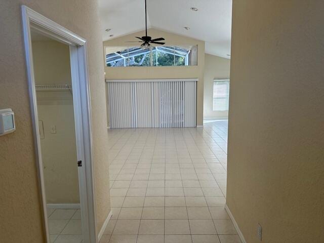 hall featuring light tile patterned floors and vaulted ceiling