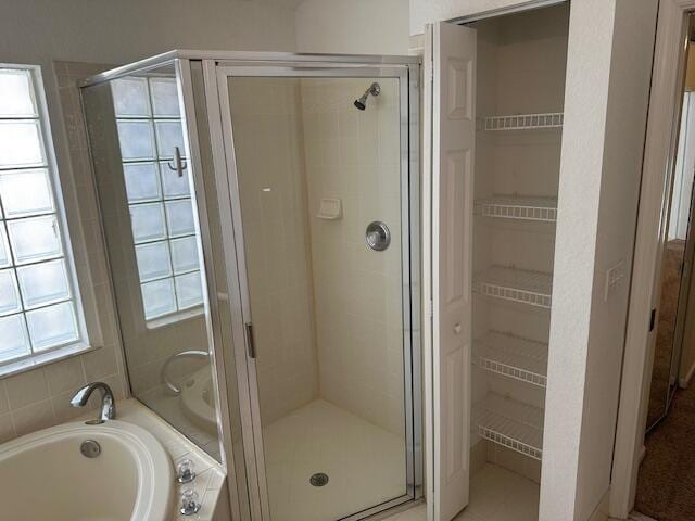 bathroom featuring plus walk in shower and a wealth of natural light