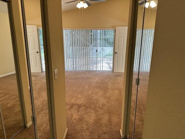 interior space with carpet floors and vaulted ceiling