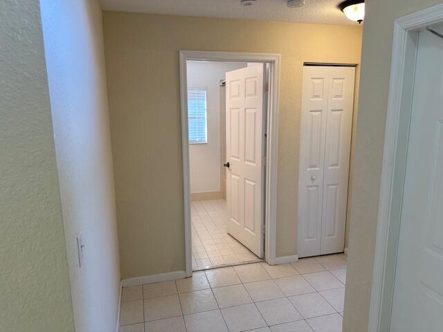 hall featuring light tile patterned flooring