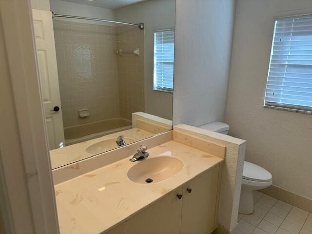 full bathroom featuring tile patterned flooring, vanity, toilet, and tiled shower / bath