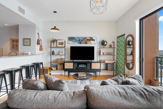 living room featuring a chandelier and light hardwood / wood-style flooring