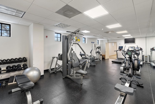 exercise room featuring a paneled ceiling and a wealth of natural light