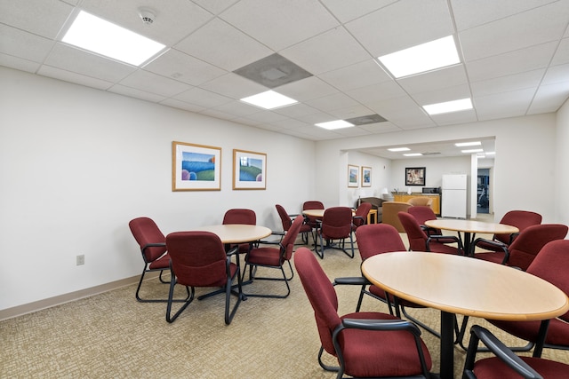 dining room with light carpet and a drop ceiling