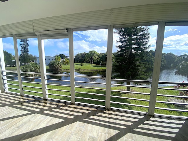 unfurnished sunroom with a water view