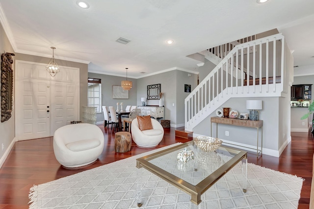 living room featuring dark hardwood / wood-style floors, crown molding, and a chandelier