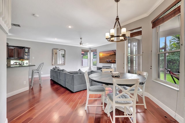 dining space featuring ceiling fan with notable chandelier, dark hardwood / wood-style floors, and crown molding