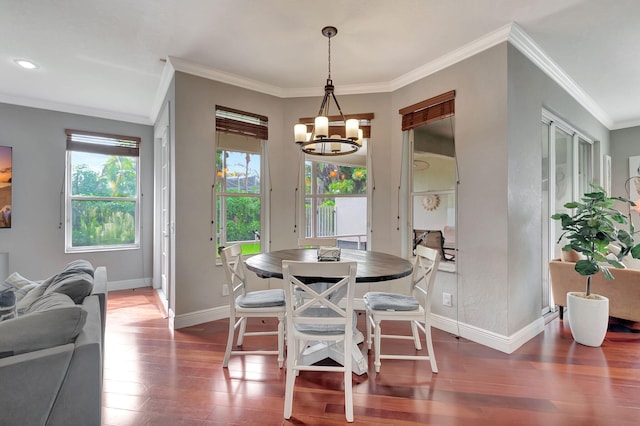 dining space with ornamental molding, dark wood-type flooring, and a chandelier