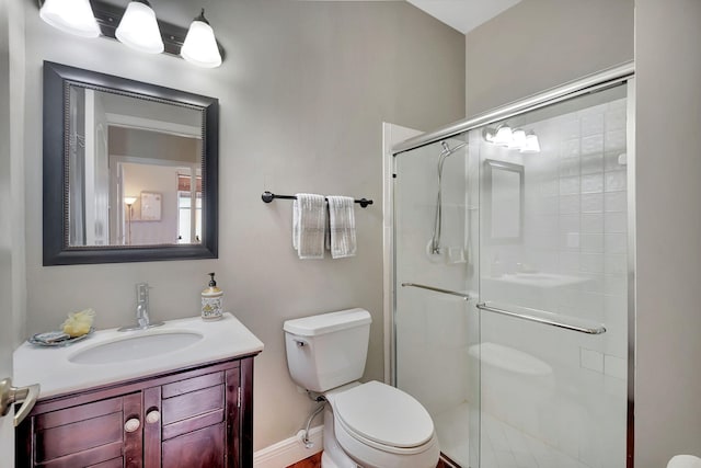 bathroom with vanity, toilet, and a shower with shower door