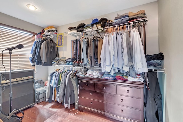 walk in closet with light hardwood / wood-style flooring