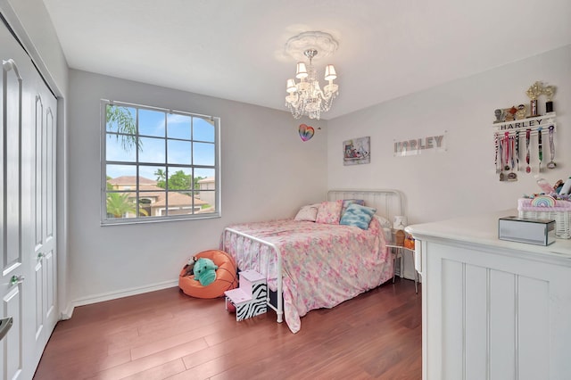 bedroom with a chandelier, a closet, and dark wood-type flooring