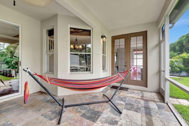 sunroom / solarium featuring french doors and a notable chandelier