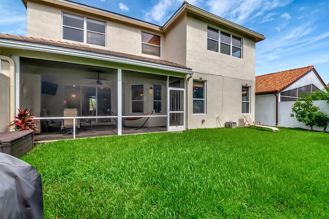 back of house with a yard, ceiling fan, and a sunroom