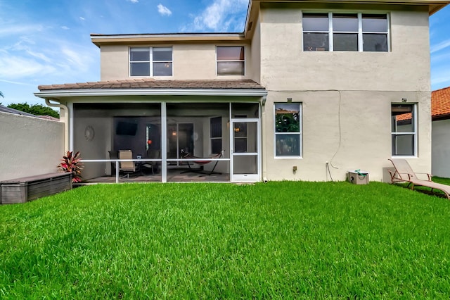 back of property featuring a lawn and a sunroom