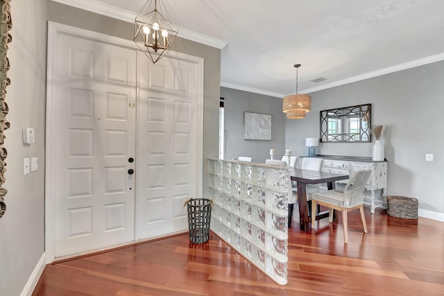 entryway featuring hardwood / wood-style floors, an inviting chandelier, and ornamental molding