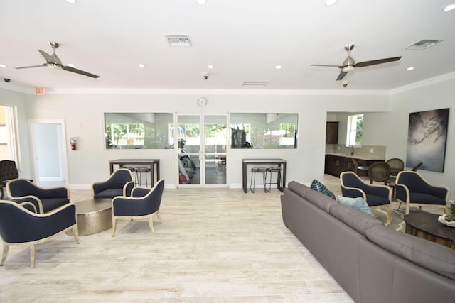 living room featuring light wood-type flooring and crown molding