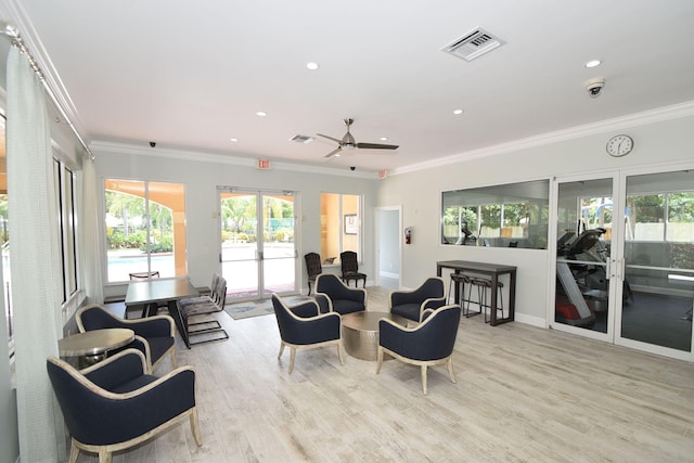 living room featuring light hardwood / wood-style floors, ceiling fan, and crown molding