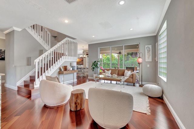 living room with crown molding, dark hardwood / wood-style floors, and a notable chandelier