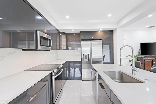 kitchen featuring light stone countertops, sink, stainless steel appliances, decorative backsplash, and ornamental molding