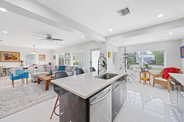 kitchen with a wealth of natural light, a center island with sink, stainless steel dishwasher, and sink