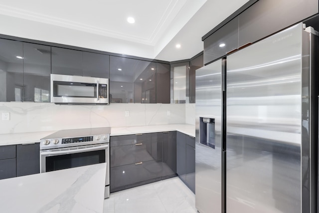 kitchen featuring backsplash, light stone counters, ornamental molding, and stainless steel appliances