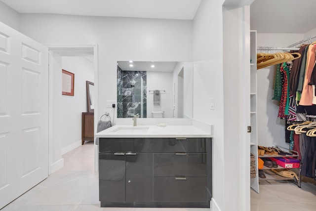 bathroom featuring tile patterned flooring, vanity, and tiled shower