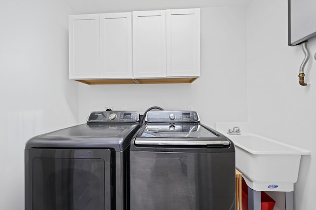 laundry area featuring sink, cabinets, and independent washer and dryer