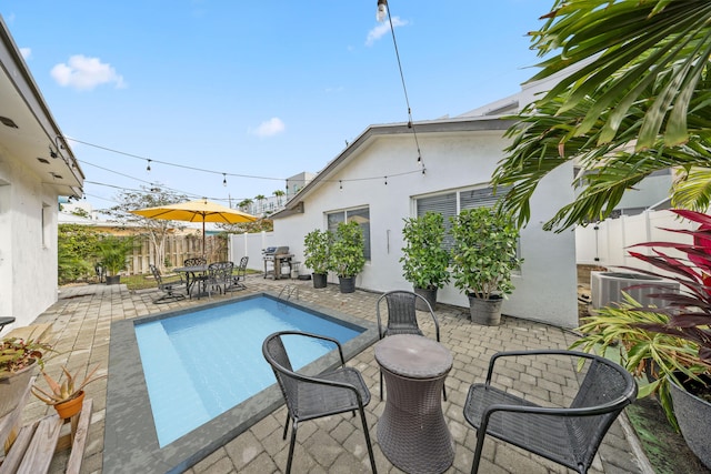 view of swimming pool featuring central air condition unit, a patio area, and a grill