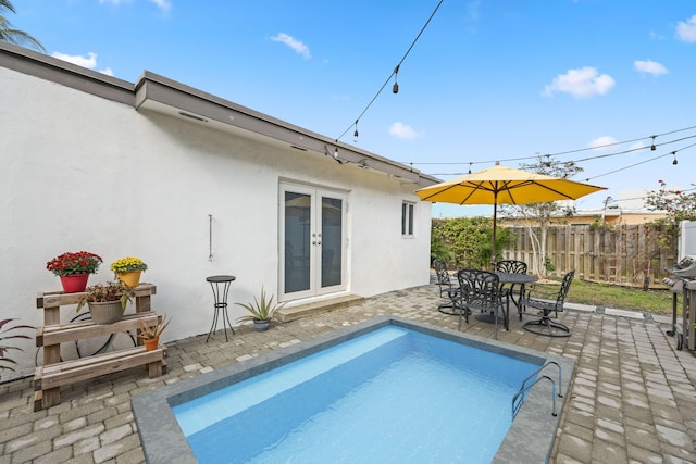 view of swimming pool with french doors and a patio