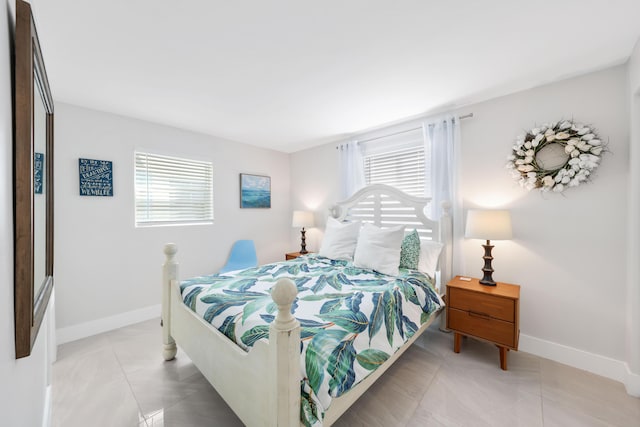 bedroom featuring light tile patterned floors and multiple windows