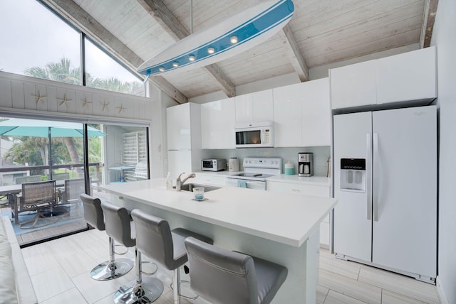 kitchen with white cabinetry, sink, a kitchen breakfast bar, lofted ceiling with beams, and white appliances